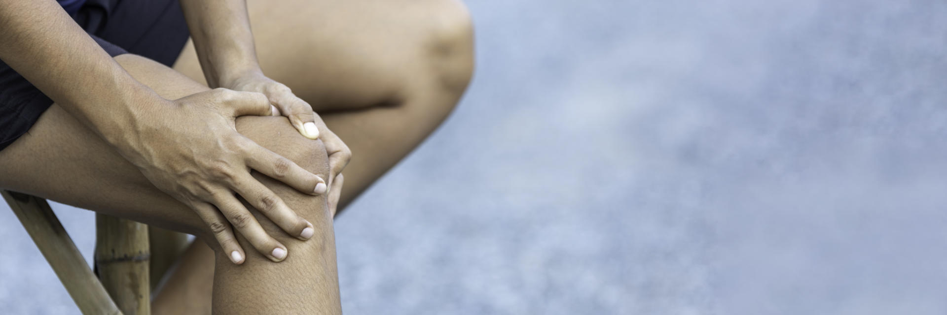 A person holding knee in pain.