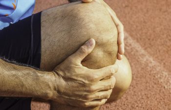 A runner holding his injured knee.