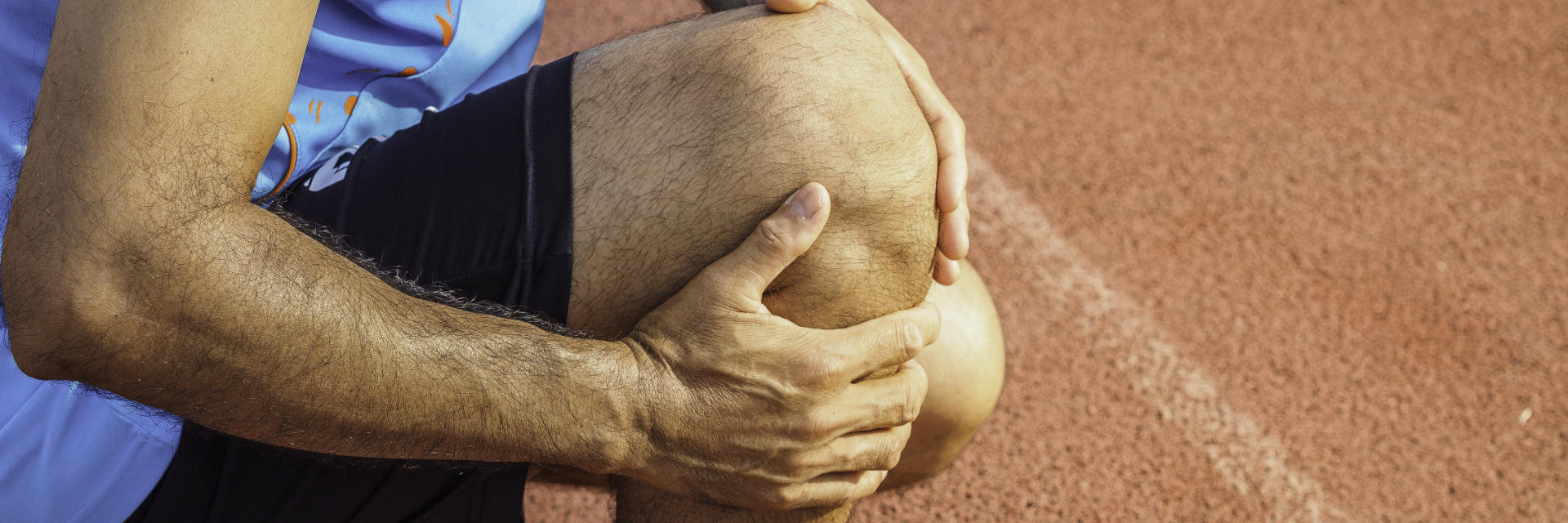 A runner holding his injured knee.