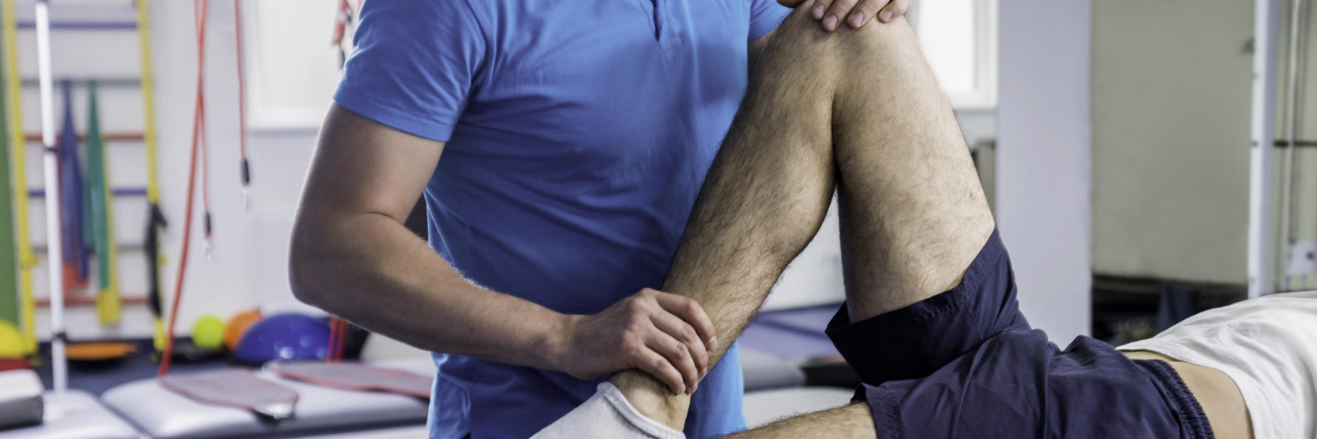 An orthopedic specialist examining patient's knee.