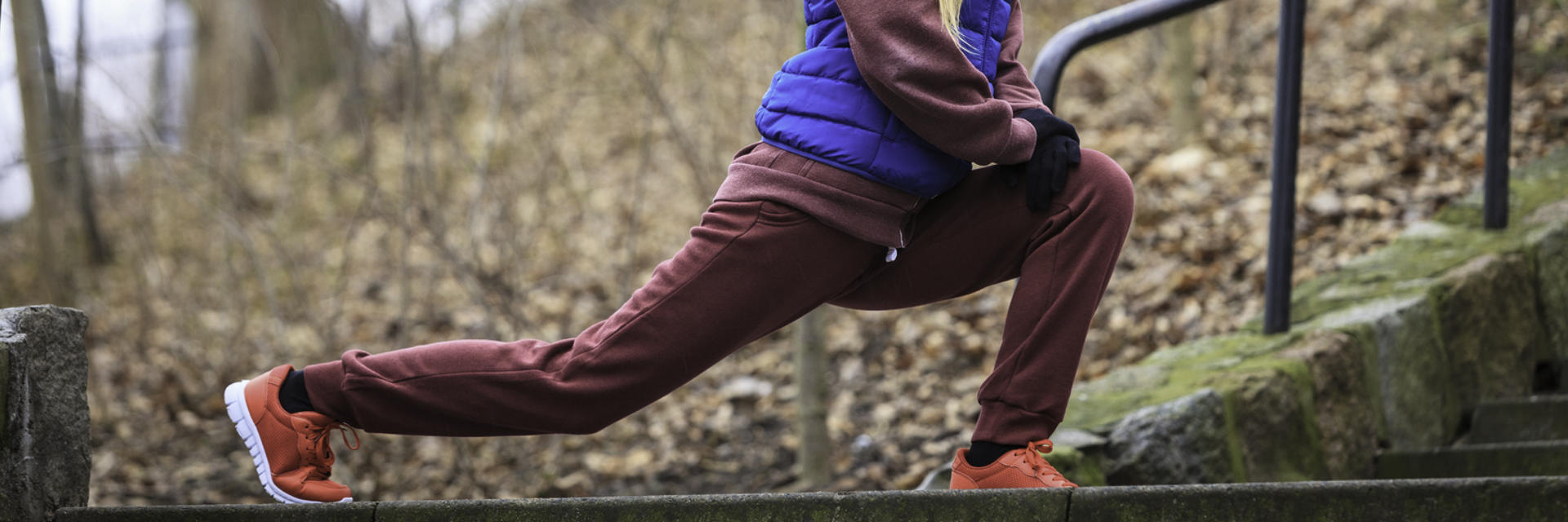 A person doing lunges for stretching in the park.