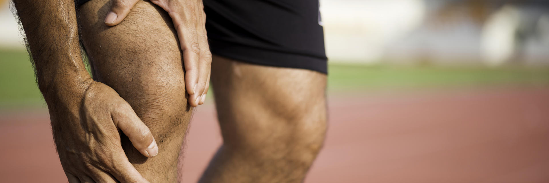 A sportsman touching the painful knee area.