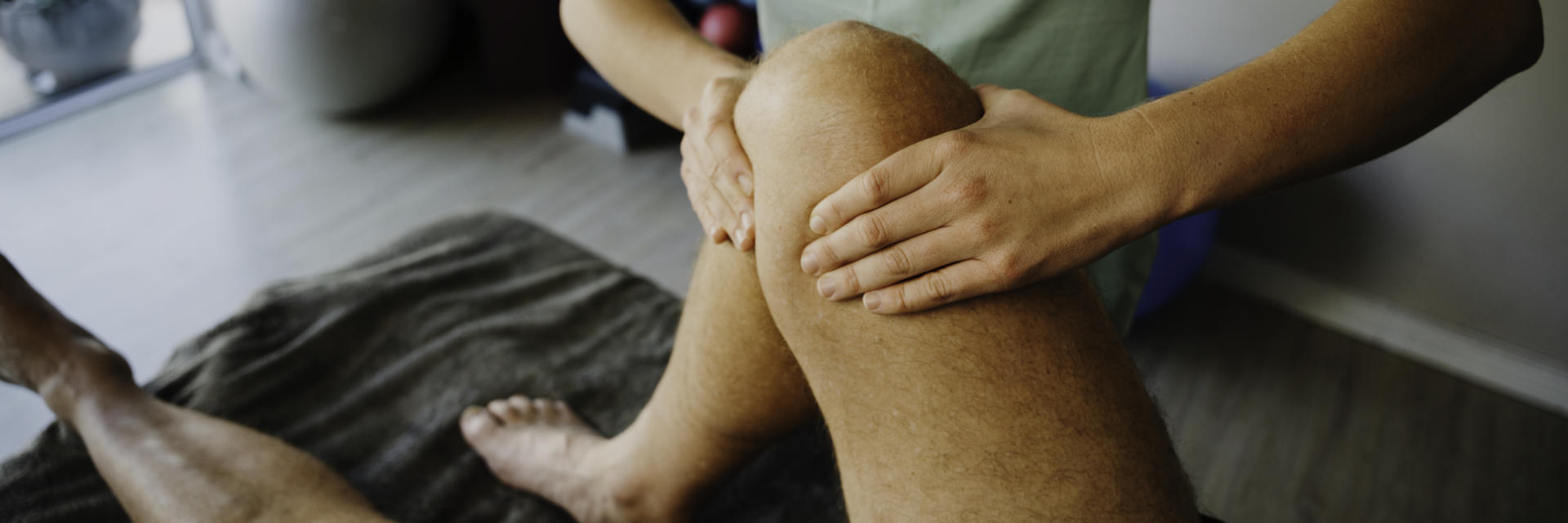 An orthopedic specialist examining patient's knee.