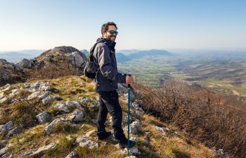 A happy middle-aged man hiking on the hills.