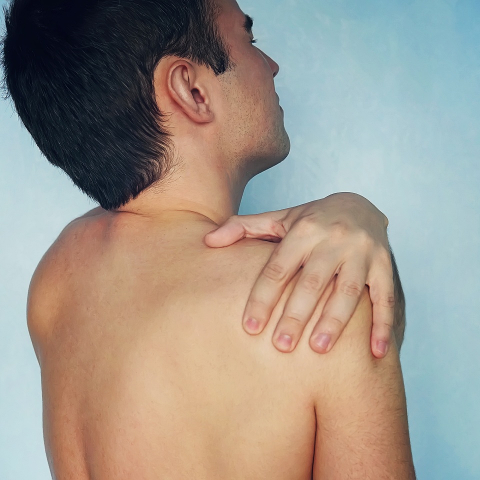 people, healthcare and problem concept - unhappy man suffering from neck or shoulder pain at home, cervical chondrosis arthrosis, fracture of the shoulder. usual dislocation of the shoulder
