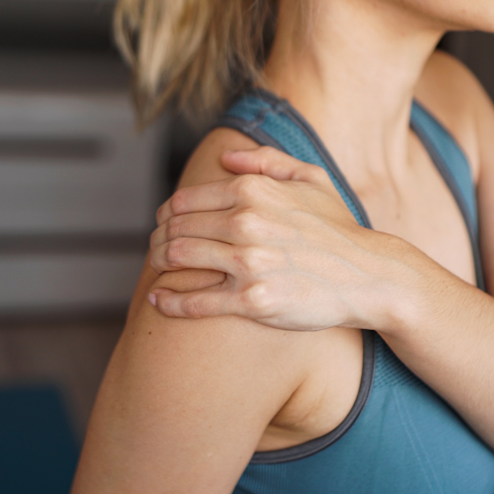 Closeup on fitness woman having pain in shoulder. Pain after home workout