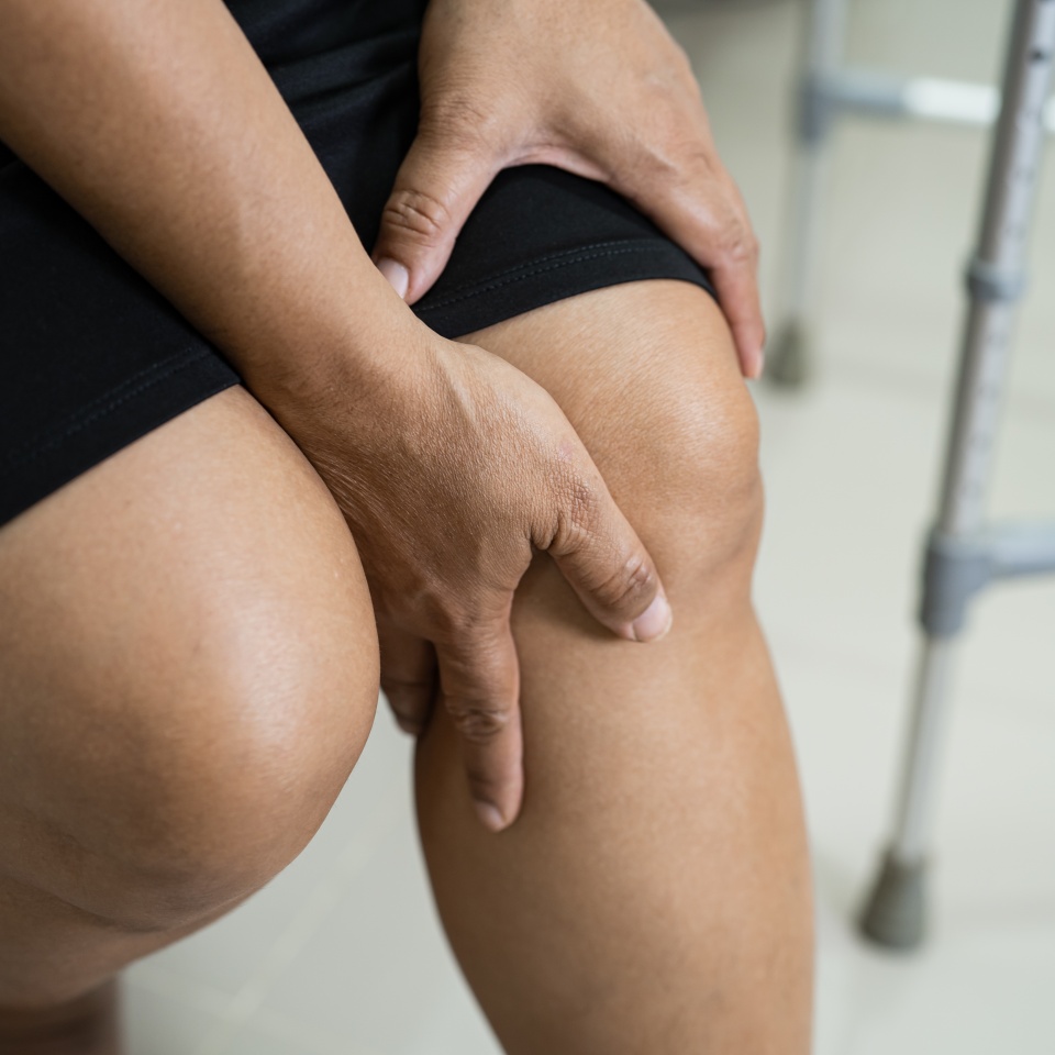 Asian lady woman patient touch and feel pain her knee, healthy medical concept.