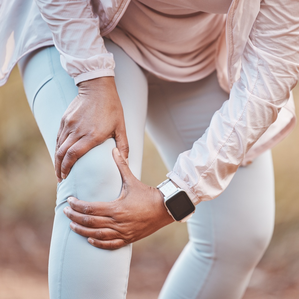 Fitness, knee pain and woman in park after running, exercise and marathon training for healthy lifestyle. Wellness, sports and hands of female athlete with muscle strain, leg injury and accident