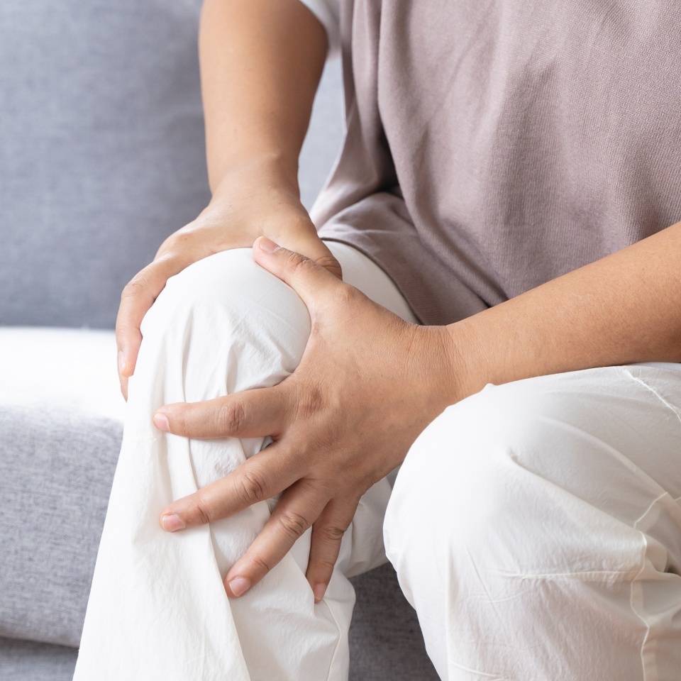 Arthritis is a chronic disease problem in elderly healthcare, Asian old female touching her leg feeling pain in her knee joint, and can't walk properly because of inflammation and pain