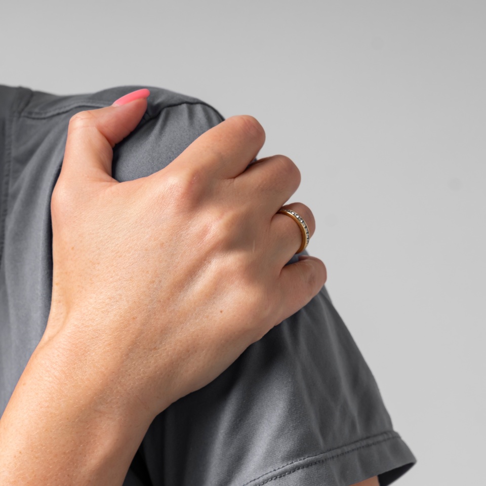 Close-up portrait of young woman suffering from shoulder pain