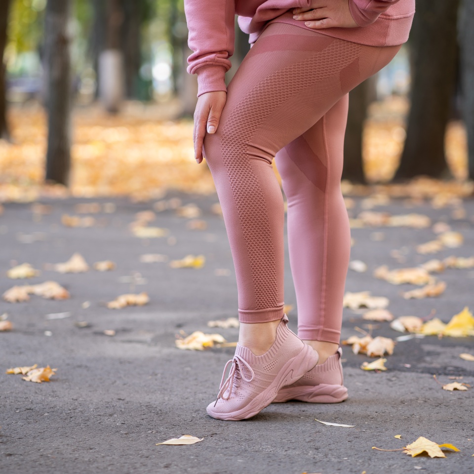 Diseases of the knee joint, bone fracture and inflammation, woman after workout suffering from pain in leg and doing self-massage, healthy lifestyle concept