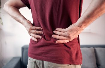Man with hip, back and sciatica pain at home.