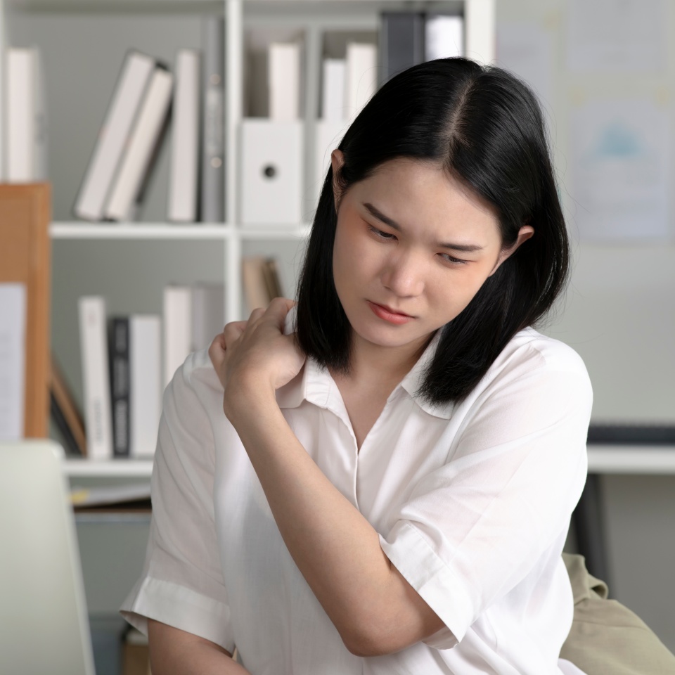Young Asian businesswoman having neck ache and shoulder pain from working in the office, Healthcare office syndrome concept